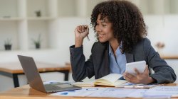 Person smiling and working on their accounting.