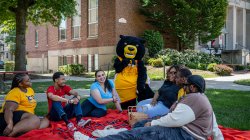 Students gather around for a picnic with the Mascot, Deacon