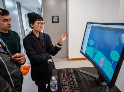 Professor looking over students' work on game design.