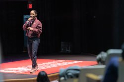 Person speaking into the mic while on stage.
