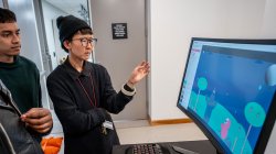 Professor looking over students' work on game design.