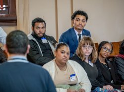 Ethan Garcia, in blue suit, and other students listen to a state official in Trenton.